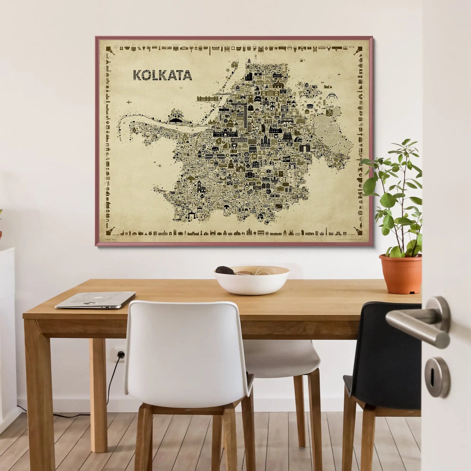 Framed map of Kolkata on a wall above a wooden table with chairs.