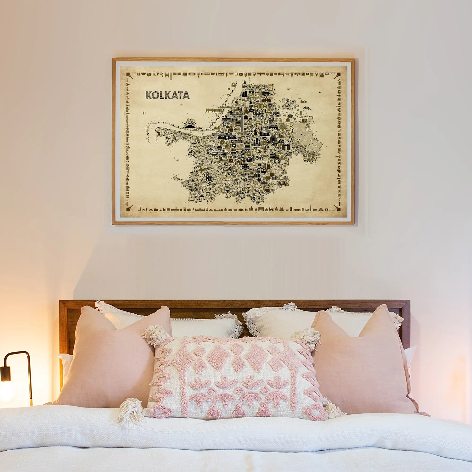 Framed map of Kolkata above a bed with decorative pillows.