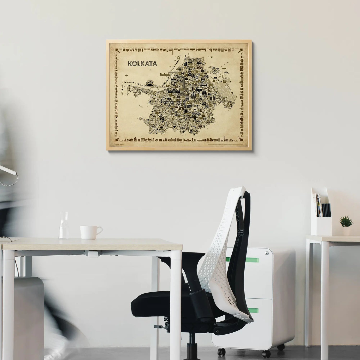 Framed map of Kolkata on a wall above a desk in an office setting