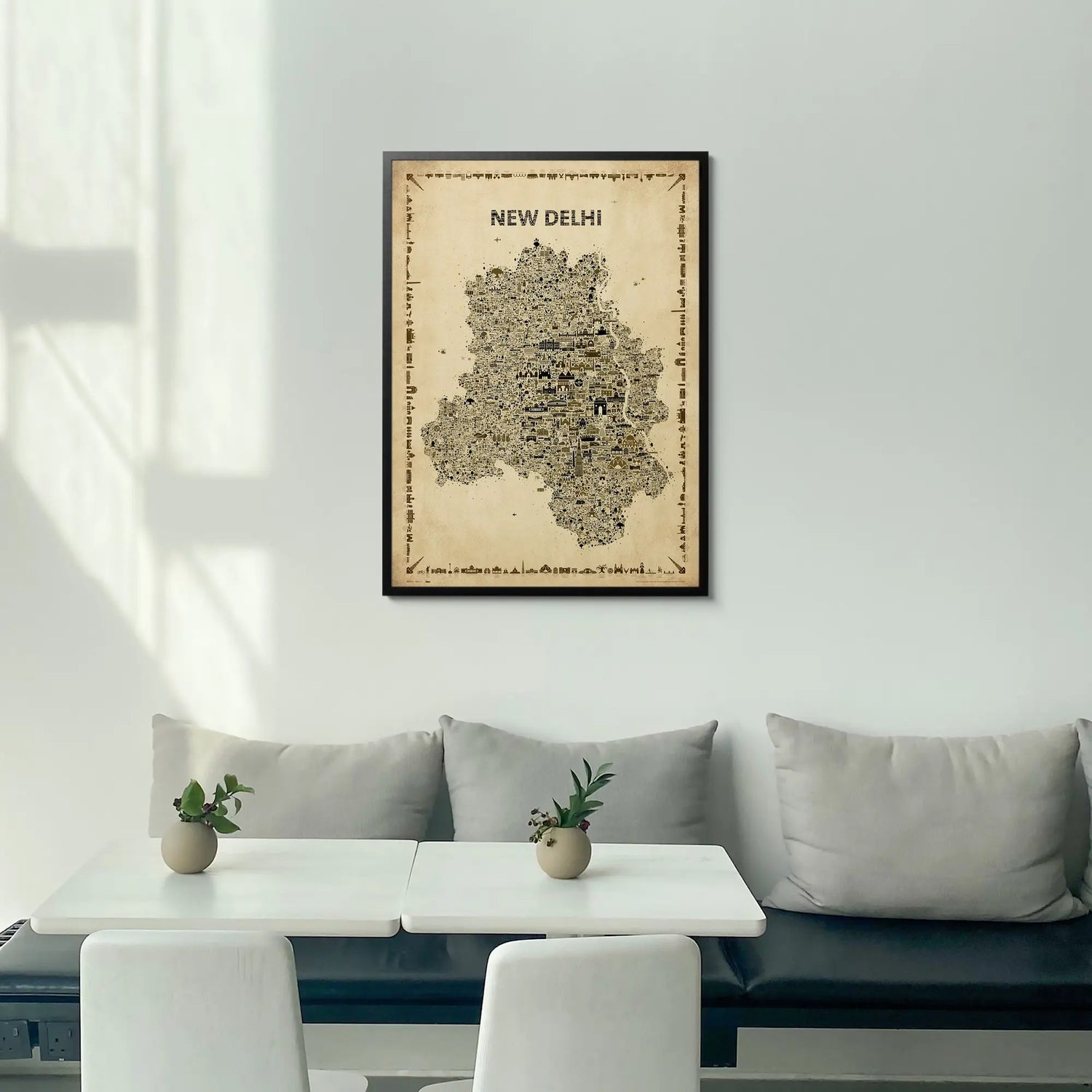 Framed map of New Delhi on a wall above a modern white sofa with a coffee table.