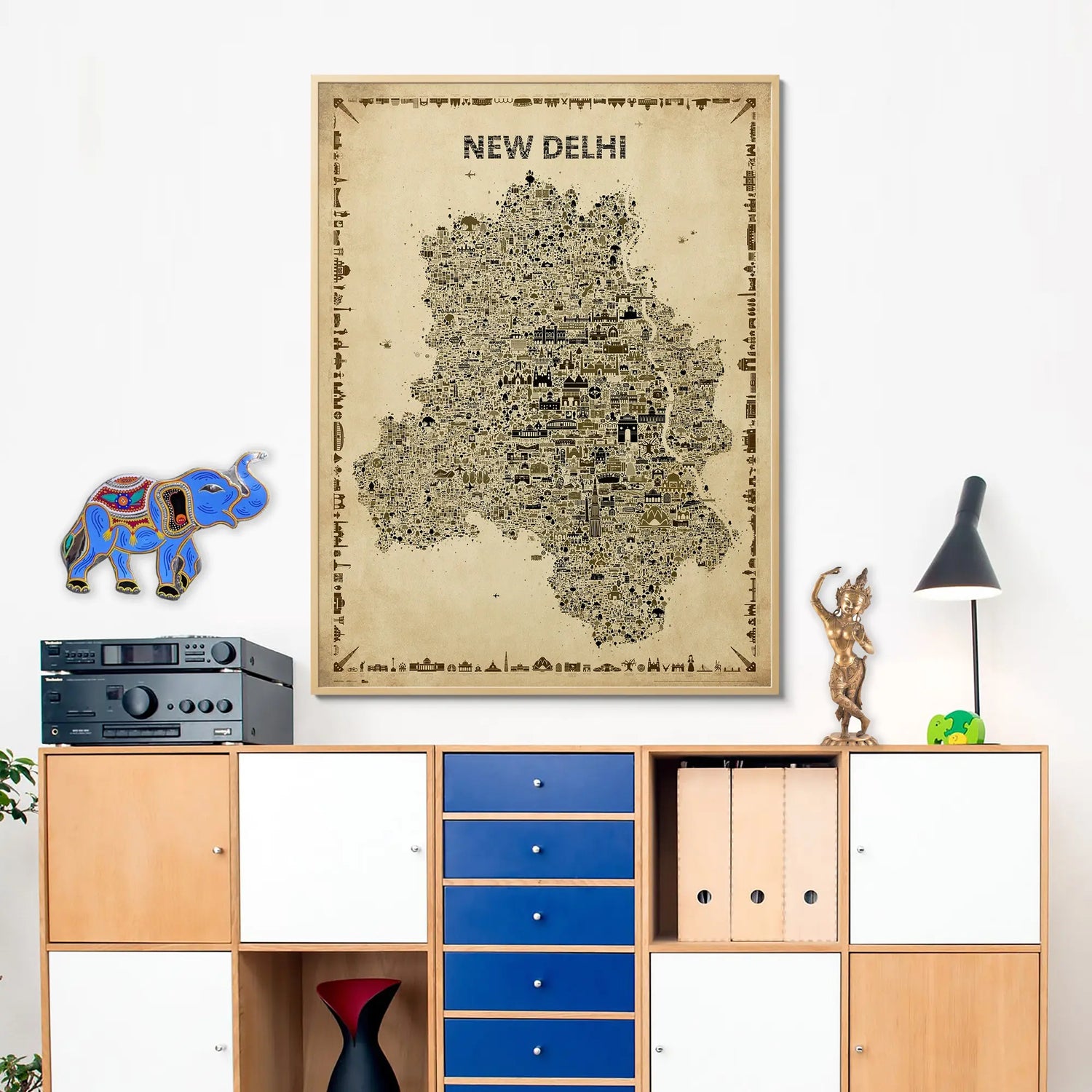 Framed map of New Delhi on a wall above a wooden cabinet with blue drawers.