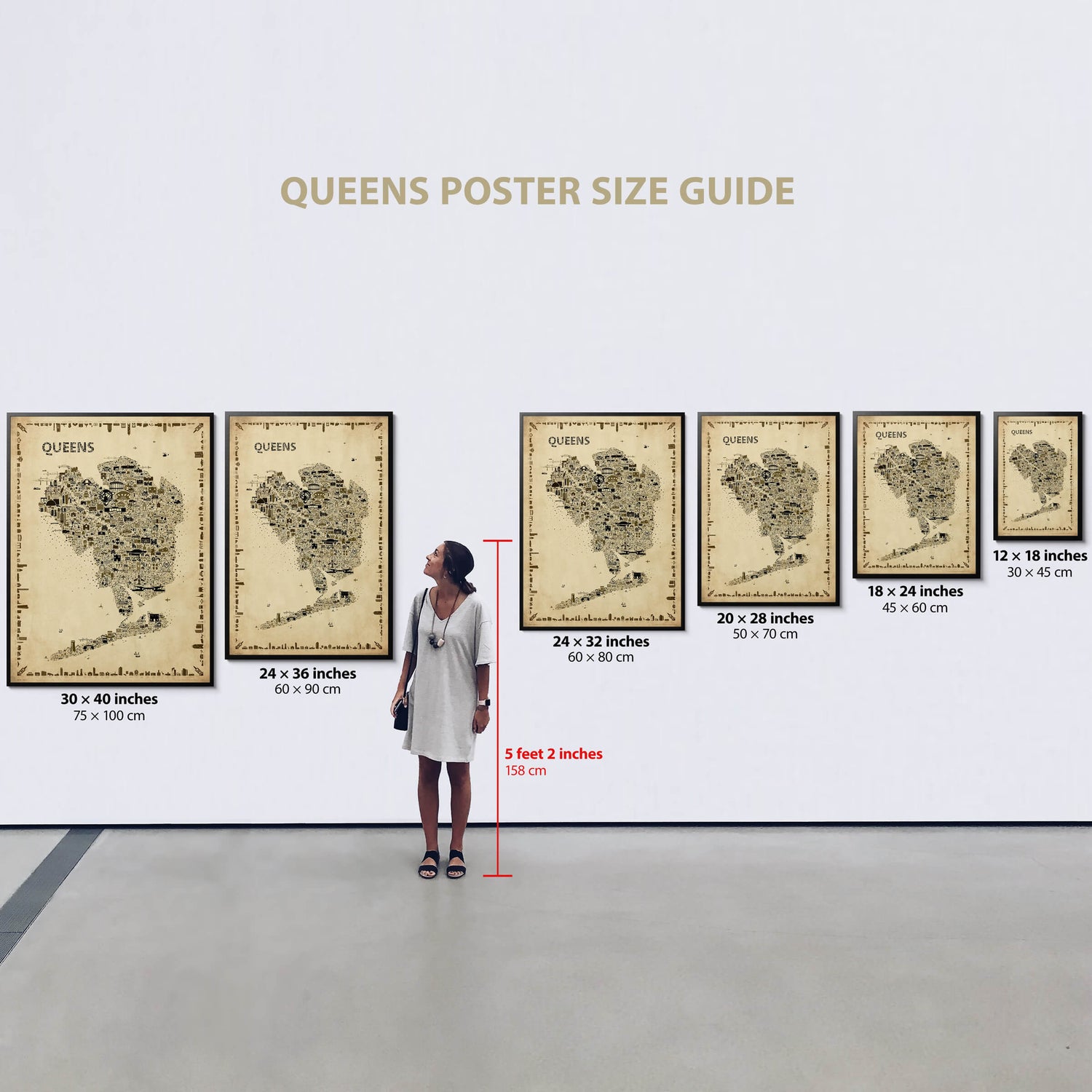 Gallery wall with six sizes of the Iconic Queens Antique Edition Poster, each framed and labeled with size, next to a 5'2" woman for scale. Elegant NYC map artwork for timeless interiors.