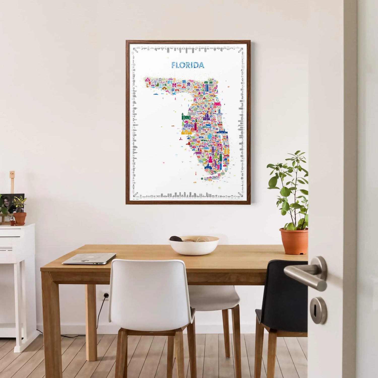 Framed map of Florida on a wall above a wooden table with chairs.