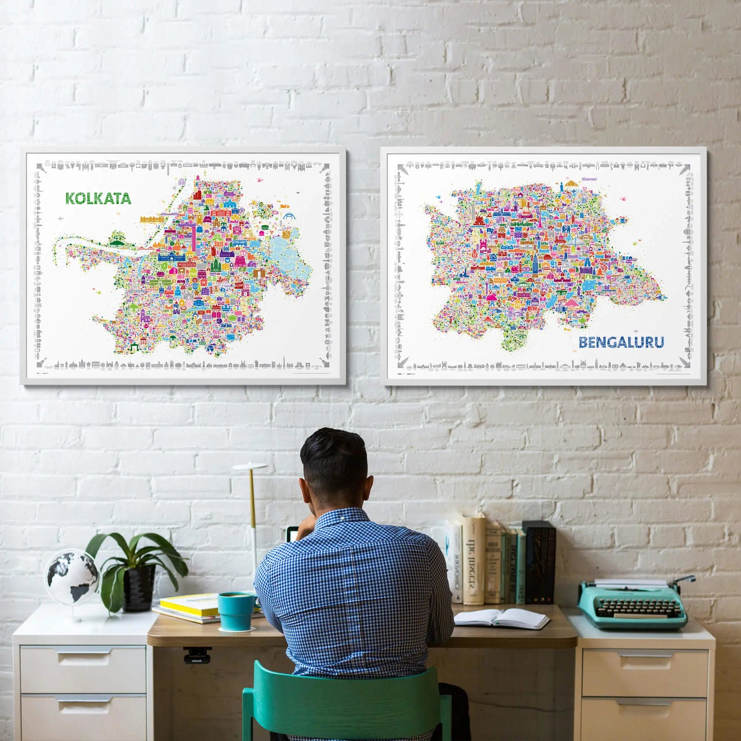 Person sitting at a desk with two maps of Kolkata and Bengaluru on the wall.
