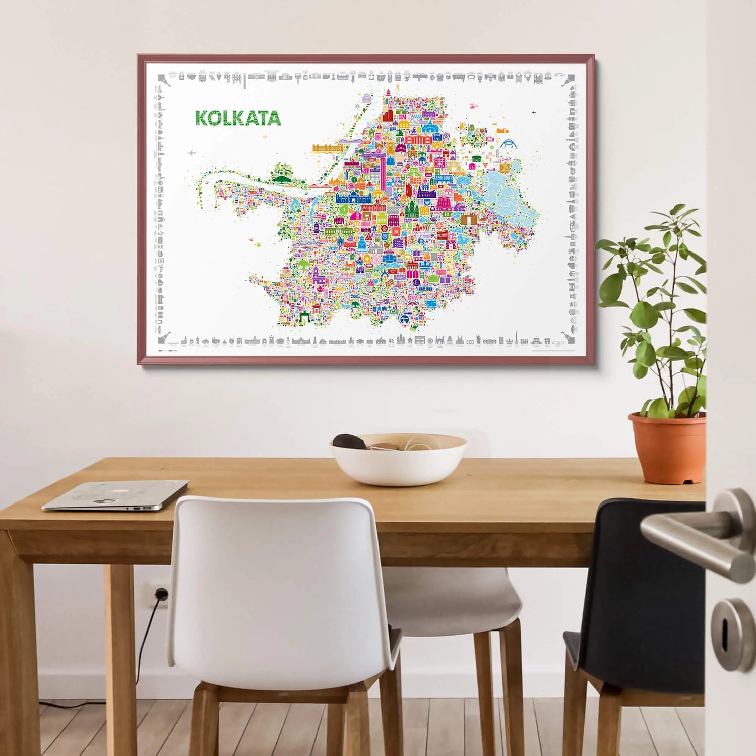 Colorful map of Kolkata framed on a wall above a wooden table.
