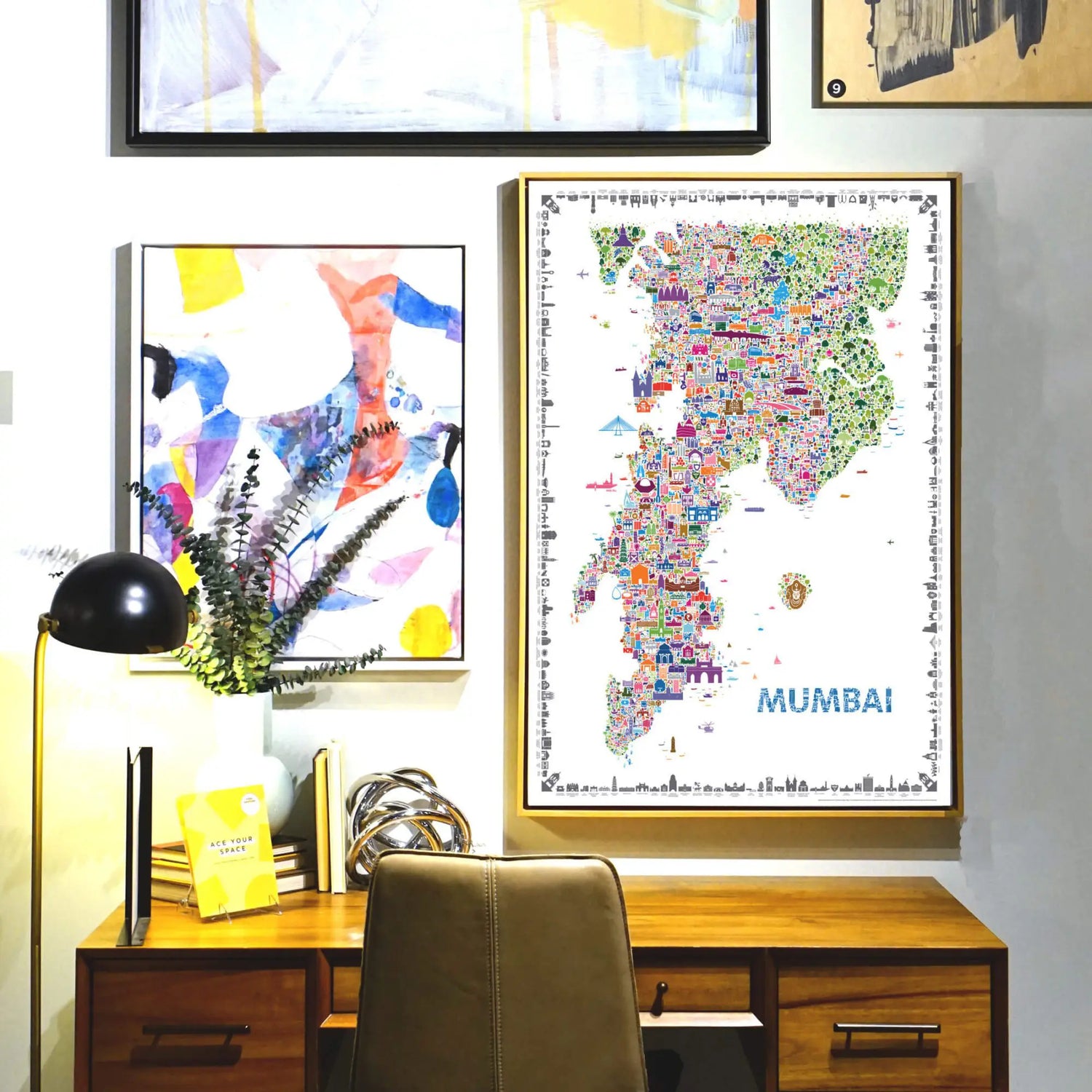 Colorful map of Mumbai on a wall above a wooden desk with decorative items.