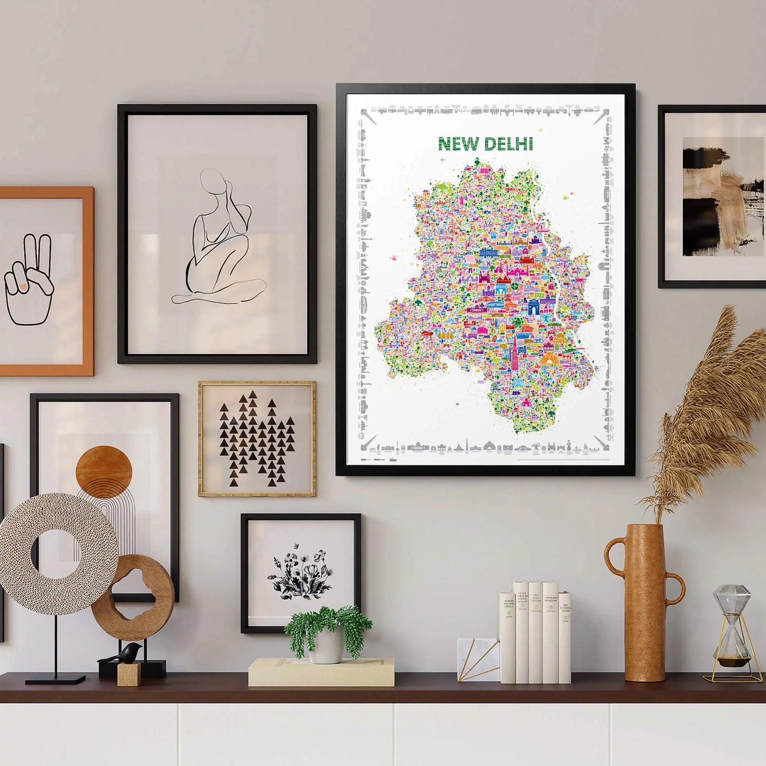 Framed New Delhi illustrated map art print displayed in a modern living room gallery wall — colorful city landmarks artwork by Alfalfa New York.