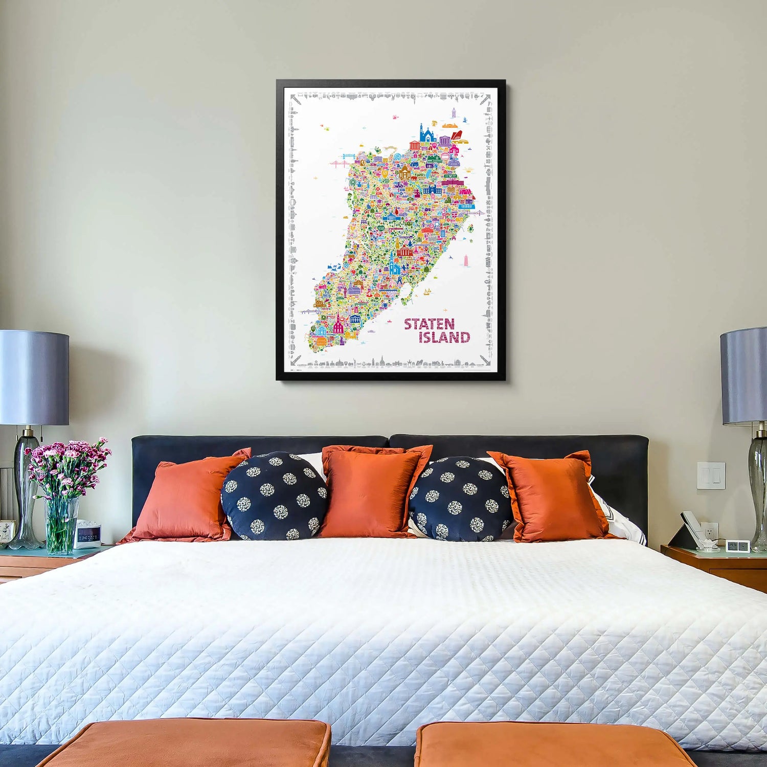 Colorful map of Staten Island on a wall above a bed with decorative pillows.