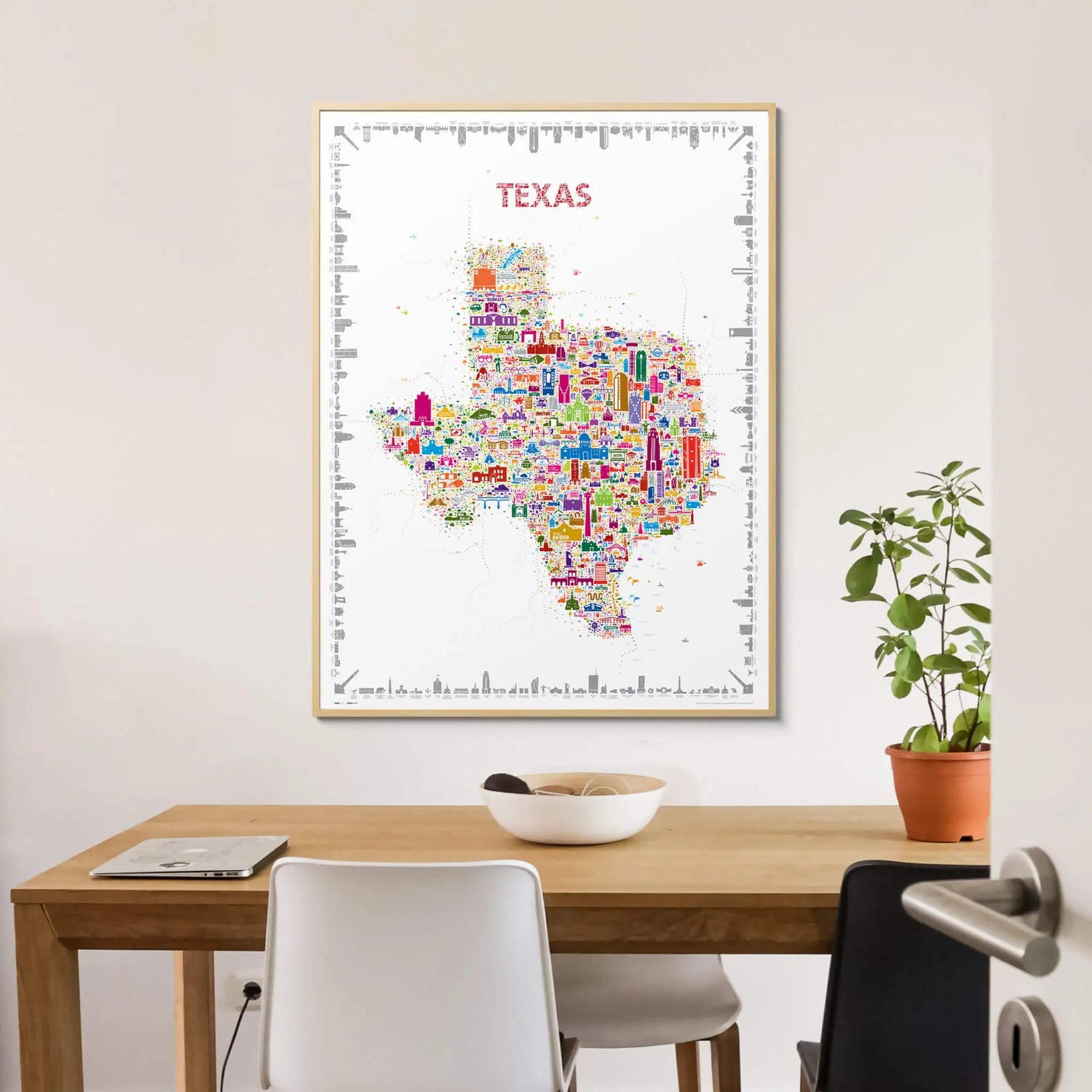 Colorful map of Texas on a wall above a wooden table with chairs.