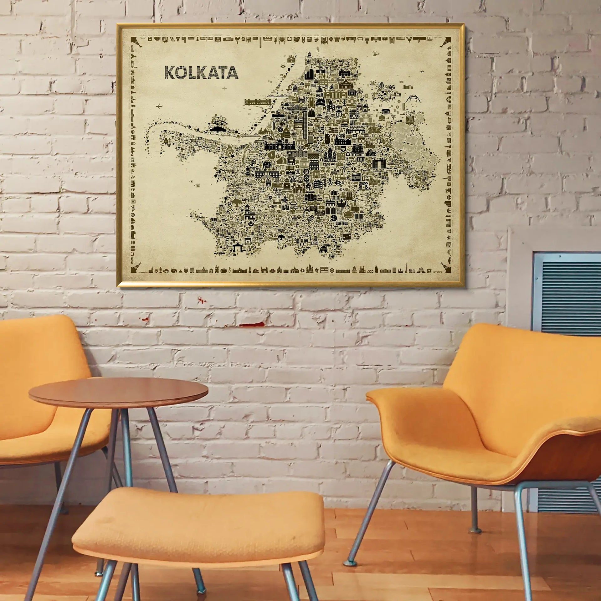 Framed map of Kolkata on a brick wall with orange chairs and a small table below.