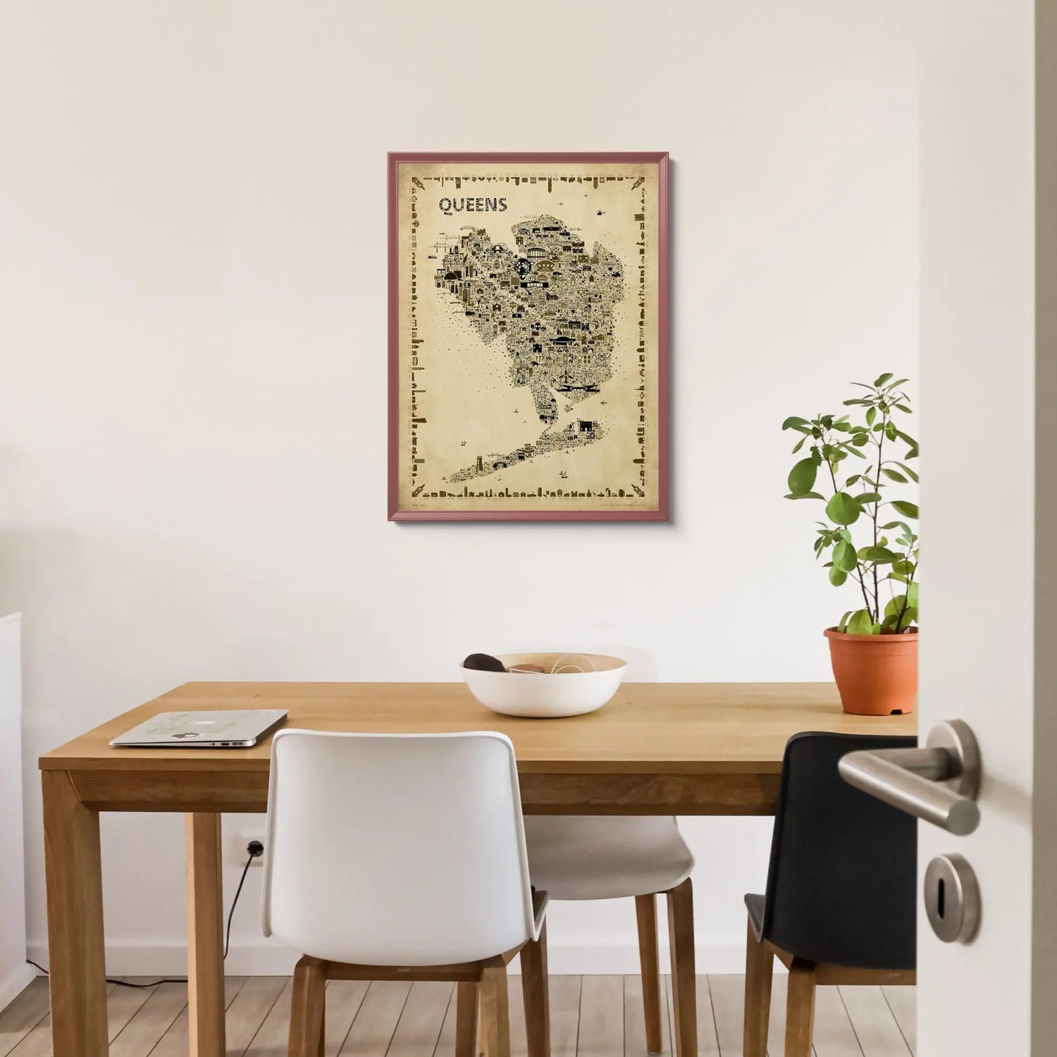 Iconic Queens antique map poster in burgundy frame hanging above wooden dining table with white chairs and potted plant
