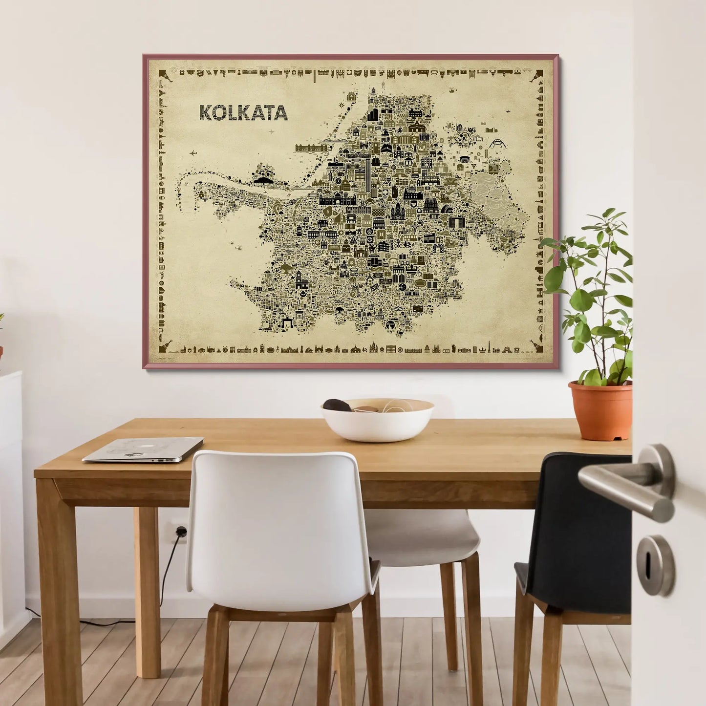Framed map of Kolkata on a wall above a wooden table with chairs.