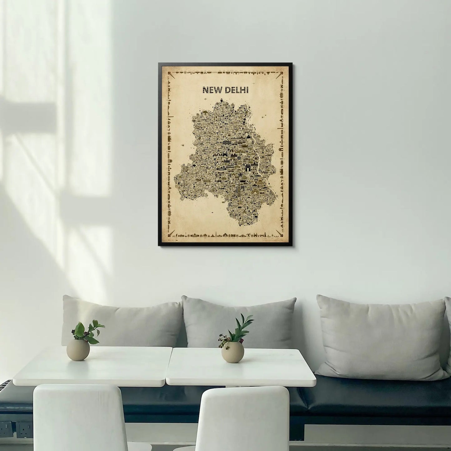 Framed map of New Delhi on a wall above a modern white sofa with a coffee table.