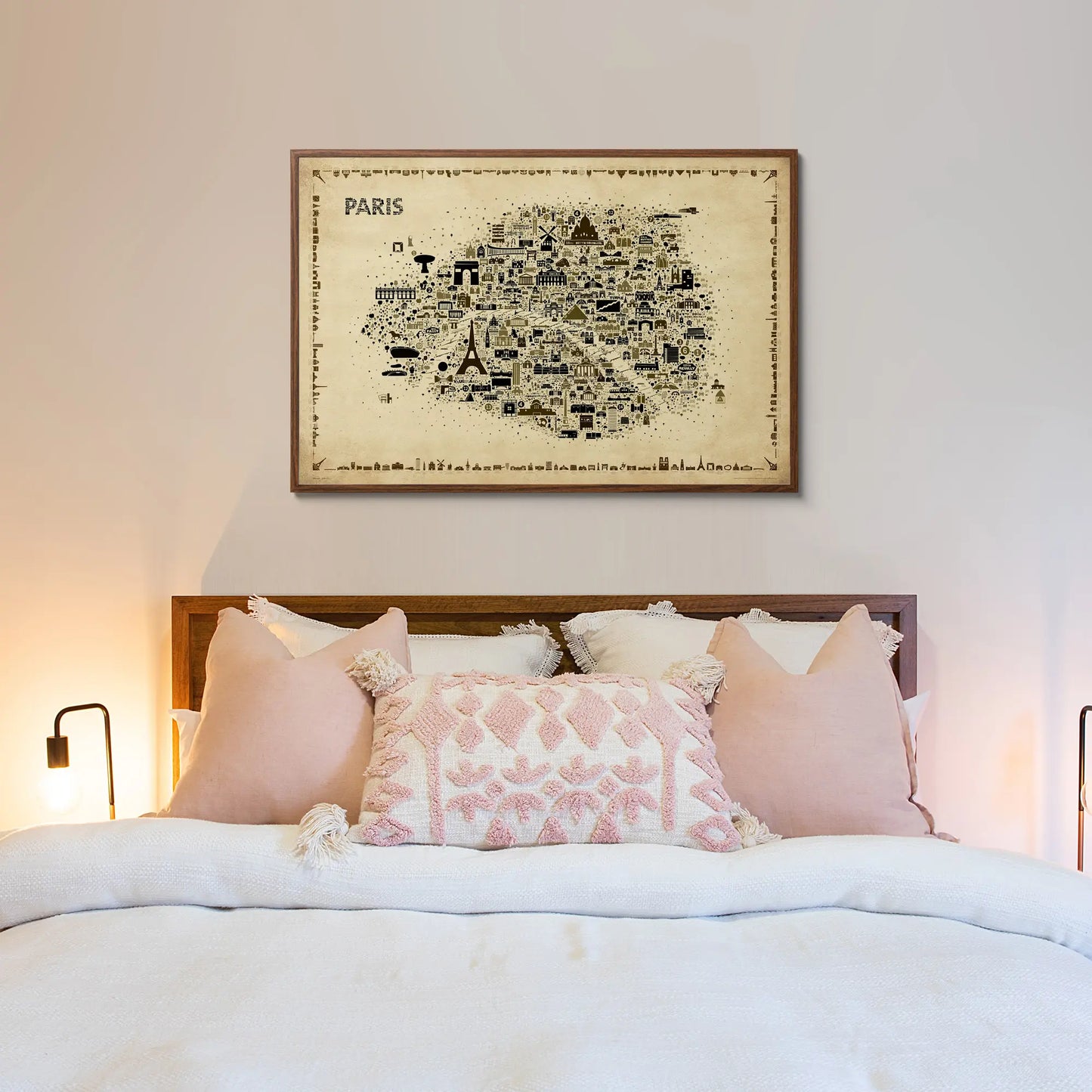 Bedroom with a map of Paris on the wall above a bed with pink and white pillows.