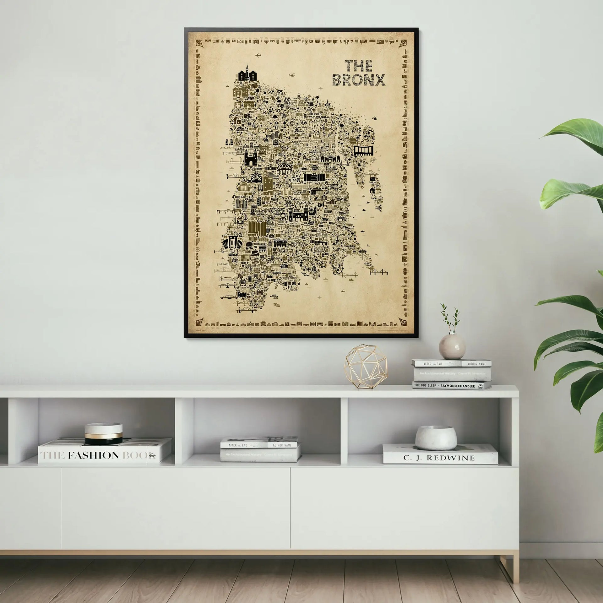 Framed map of The Bronx on a wall above a white shelf with books and decor.