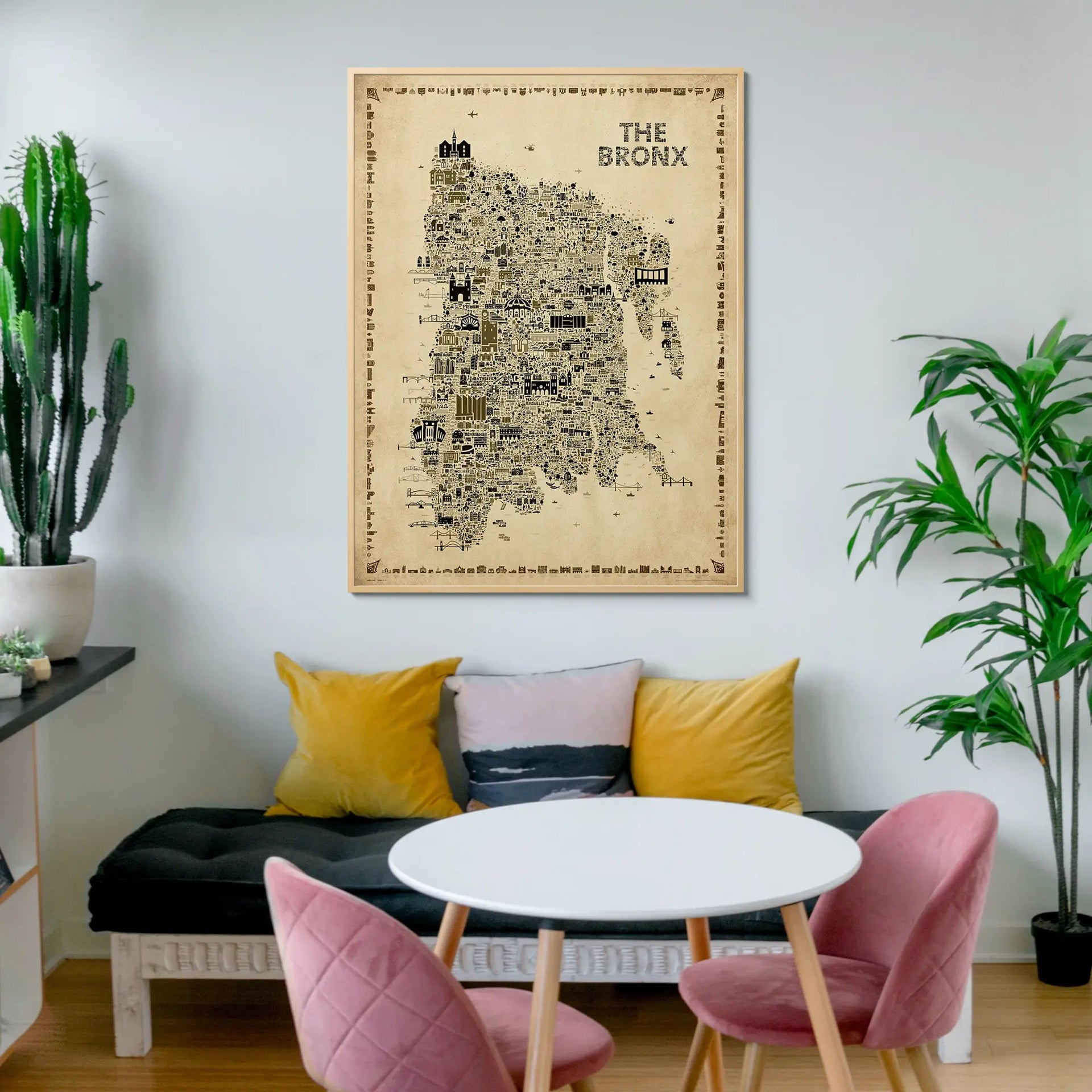 Living room with a map of The Bronx on the wall, pink chairs, and a white table.