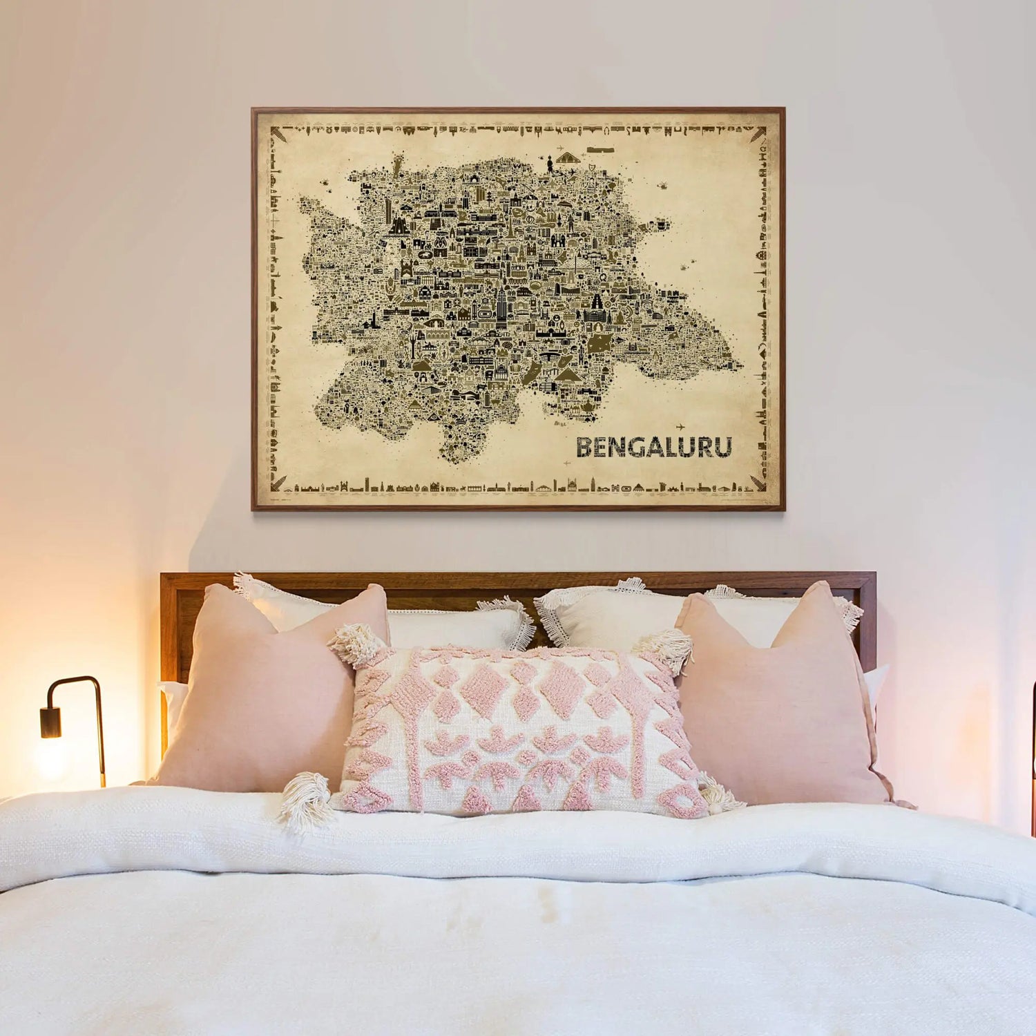 Bengaluru vintage map art print framed in wood, elegantly displayed above a modern bed with soft pastel pillows and warm lighting for a cozy bedroom aesthetic.