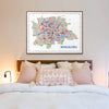 Colorful illustrated Bengaluru city map art print framed above a cozy bed with soft pink and white pillows, creating a warm and modern bedroom aesthetic.