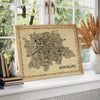 Bengaluru Antique illustrated map poster in a natural wood frame displayed by a bright window with books and dried grasses.