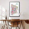 Colorful map of The Bronx on a wall above a wooden desk with a chair.