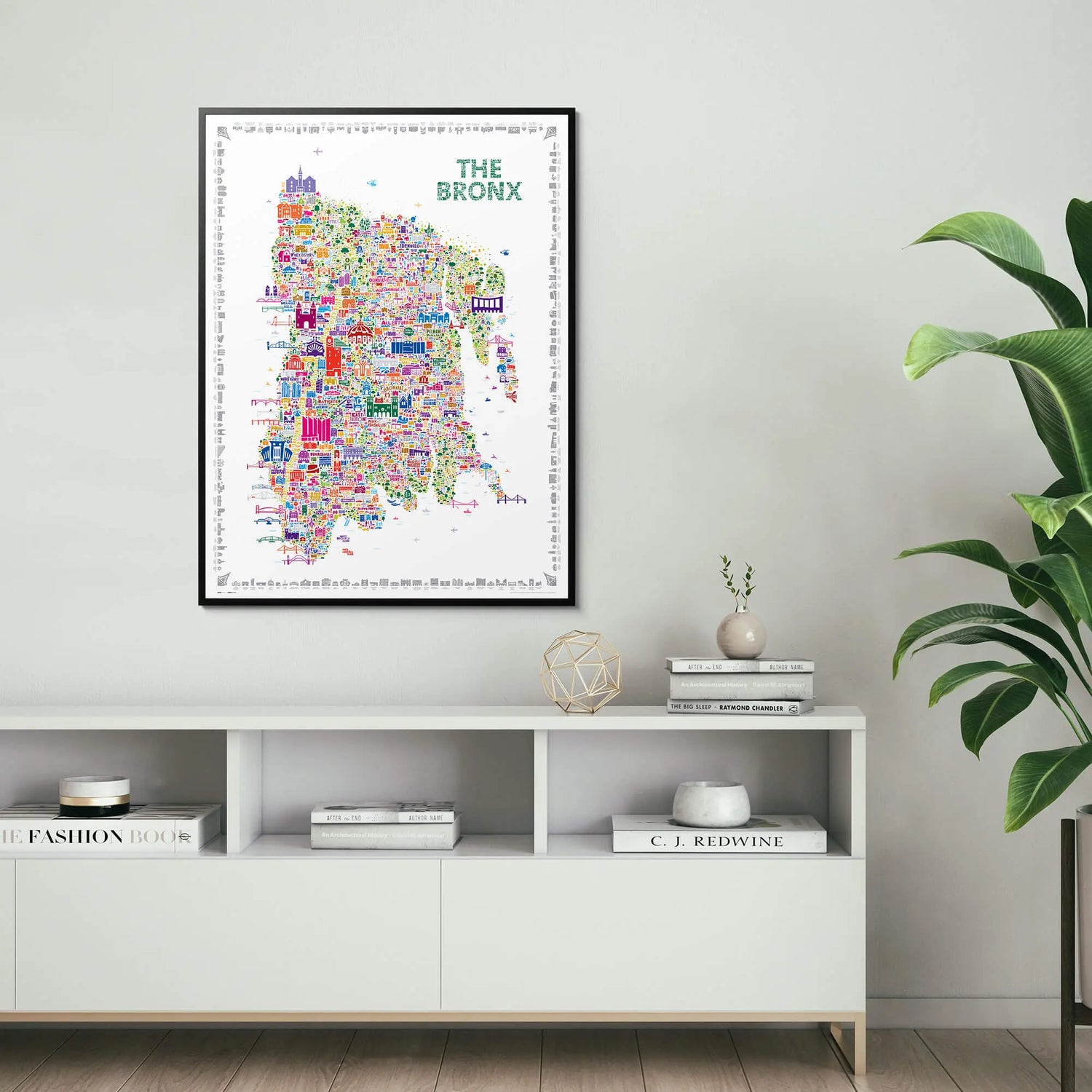 Framed map of The Bronx on a wall above a white shelf with decorative items.