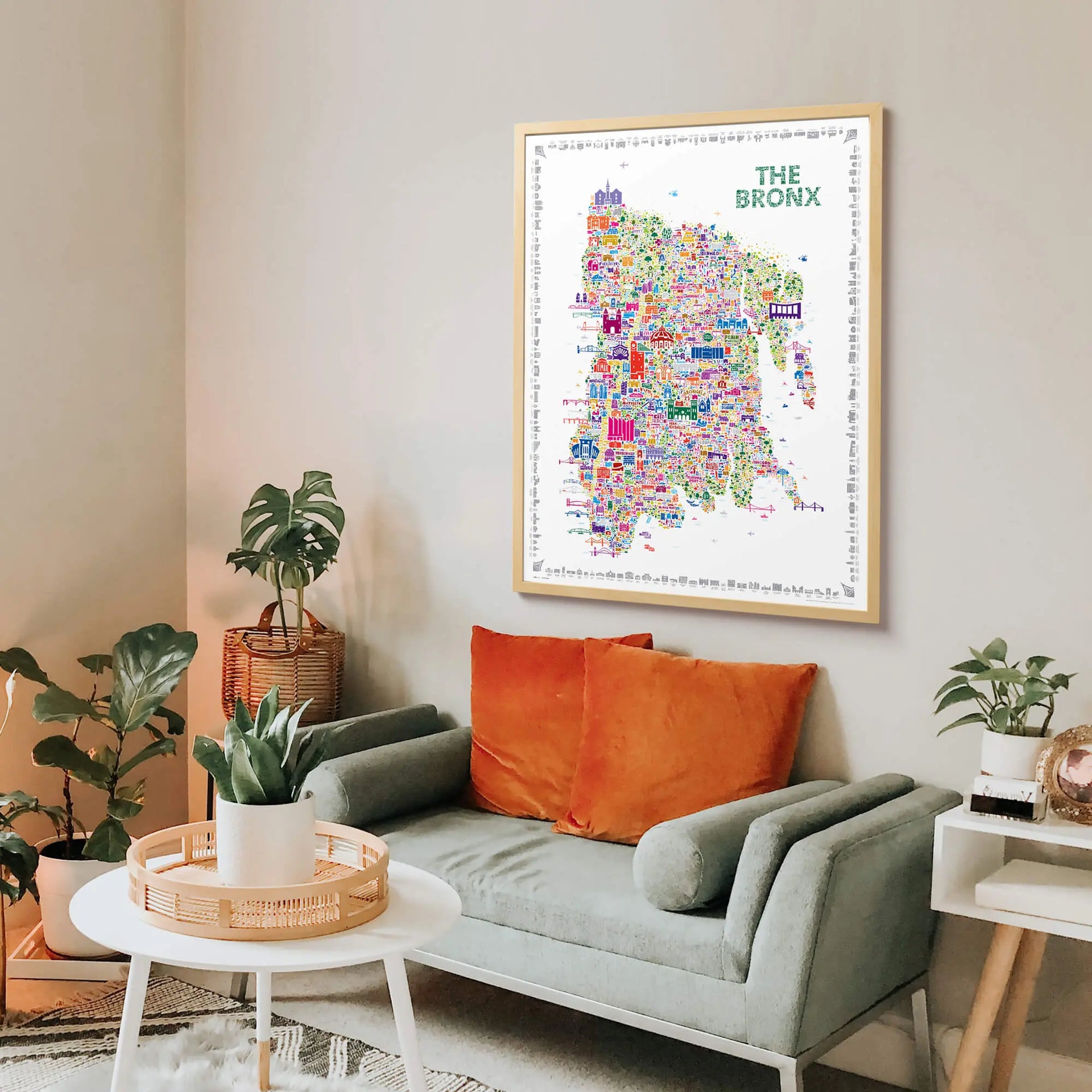 Colorful map of The Bronx on a wall above a living room with a sofa and plants.