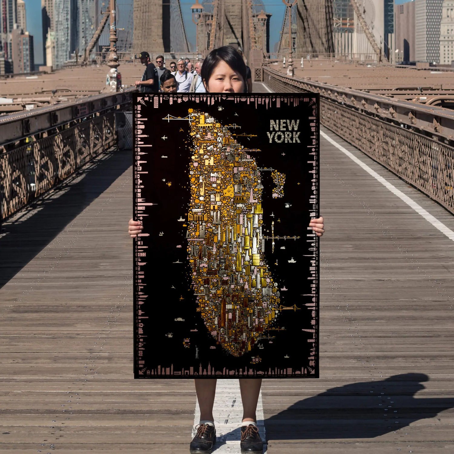 Person holding a large map of New York on a bridge