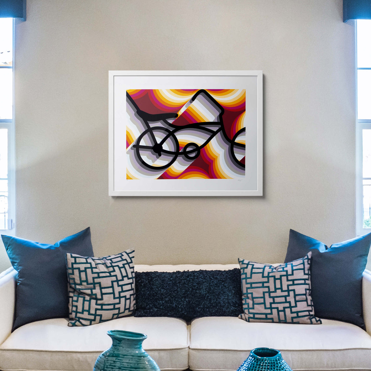 East LA Lowrider Bike screenprint in a white frame above a cream sofa with teal and navy cushions and teal vases