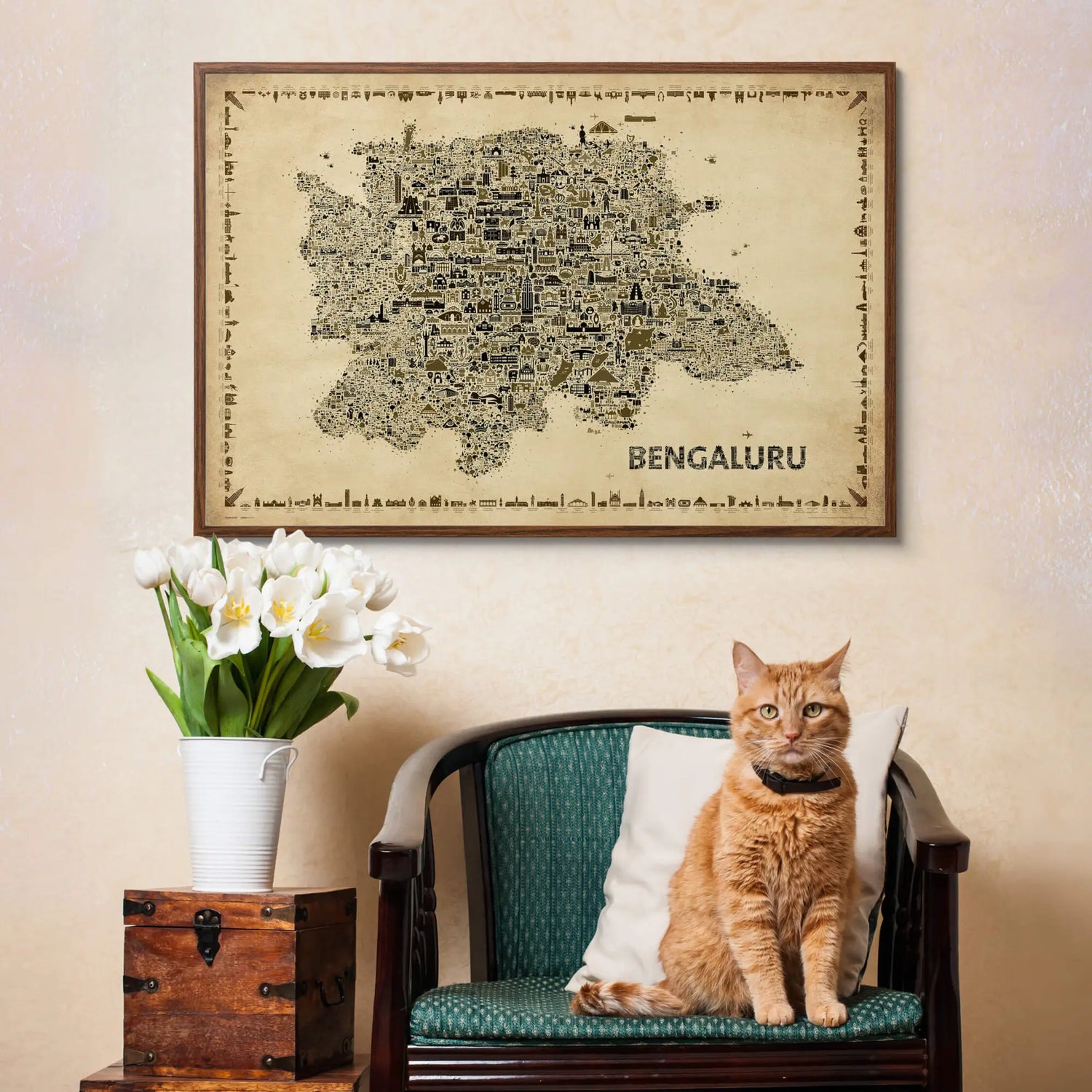 Cat sitting on a chair with a map of Bengaluru above, on a beige wall.