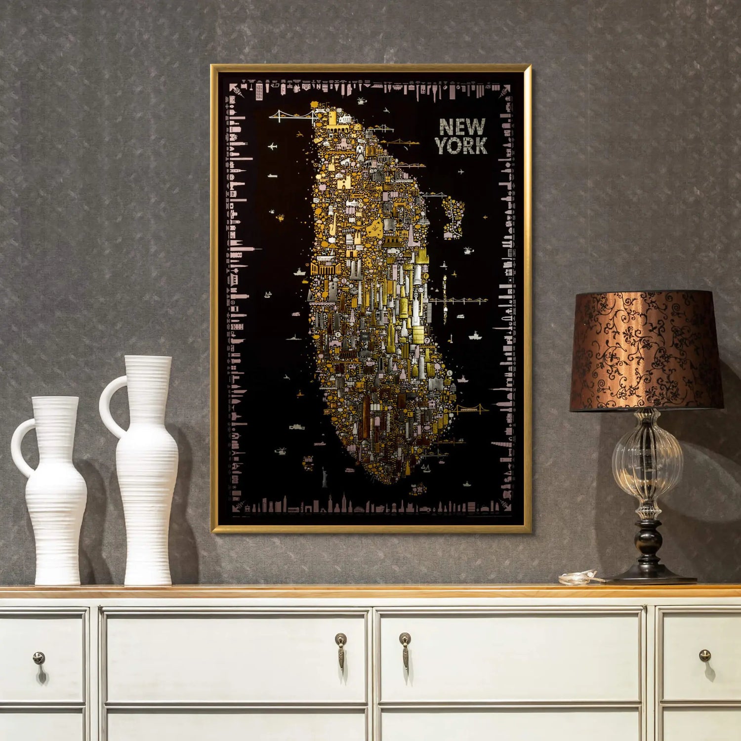 Framed map of New York on a wall above a white cabinet with decorative vases and a lamp.
