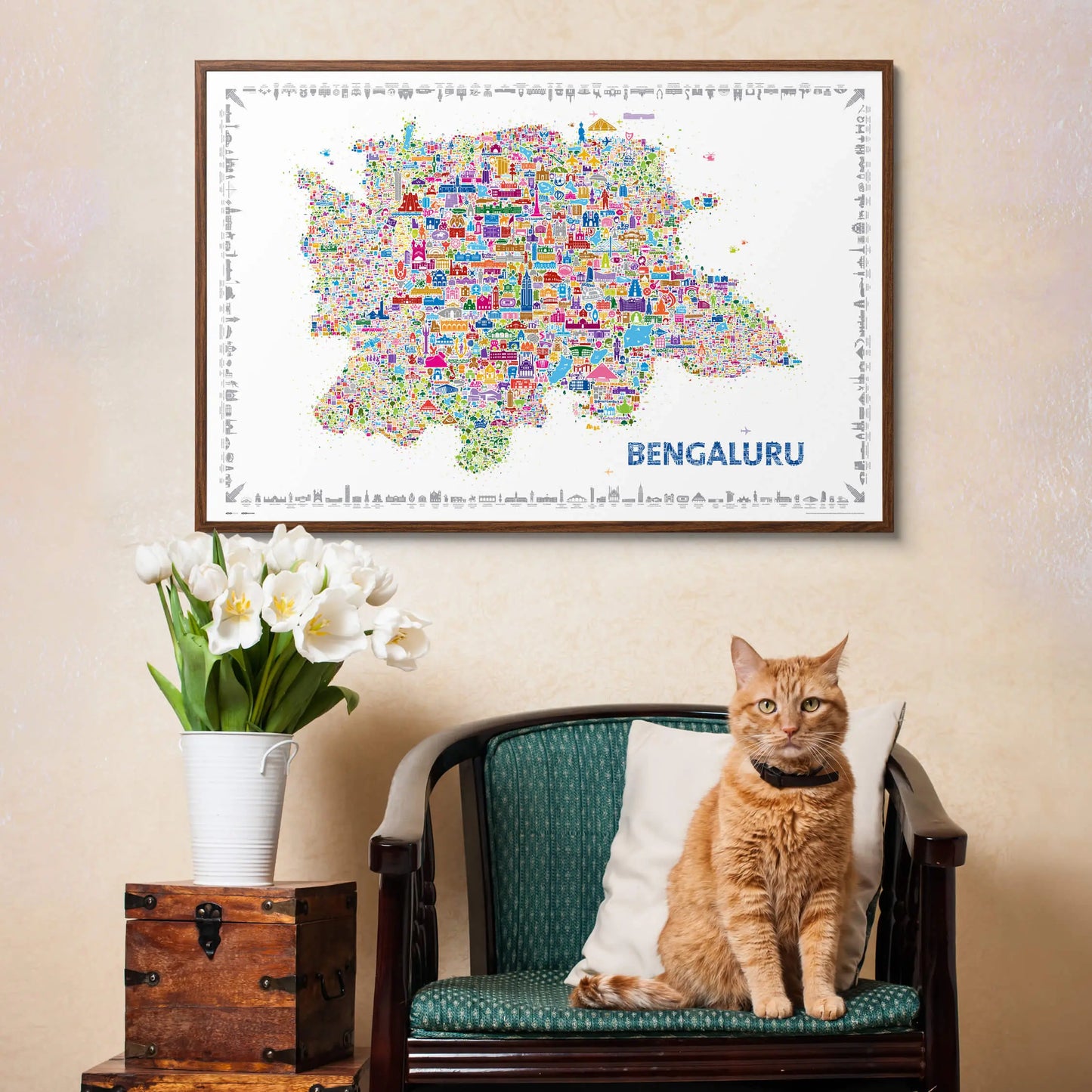 Framed map of Bangalore above a cat sitting on a chair with flowers and a wooden box.