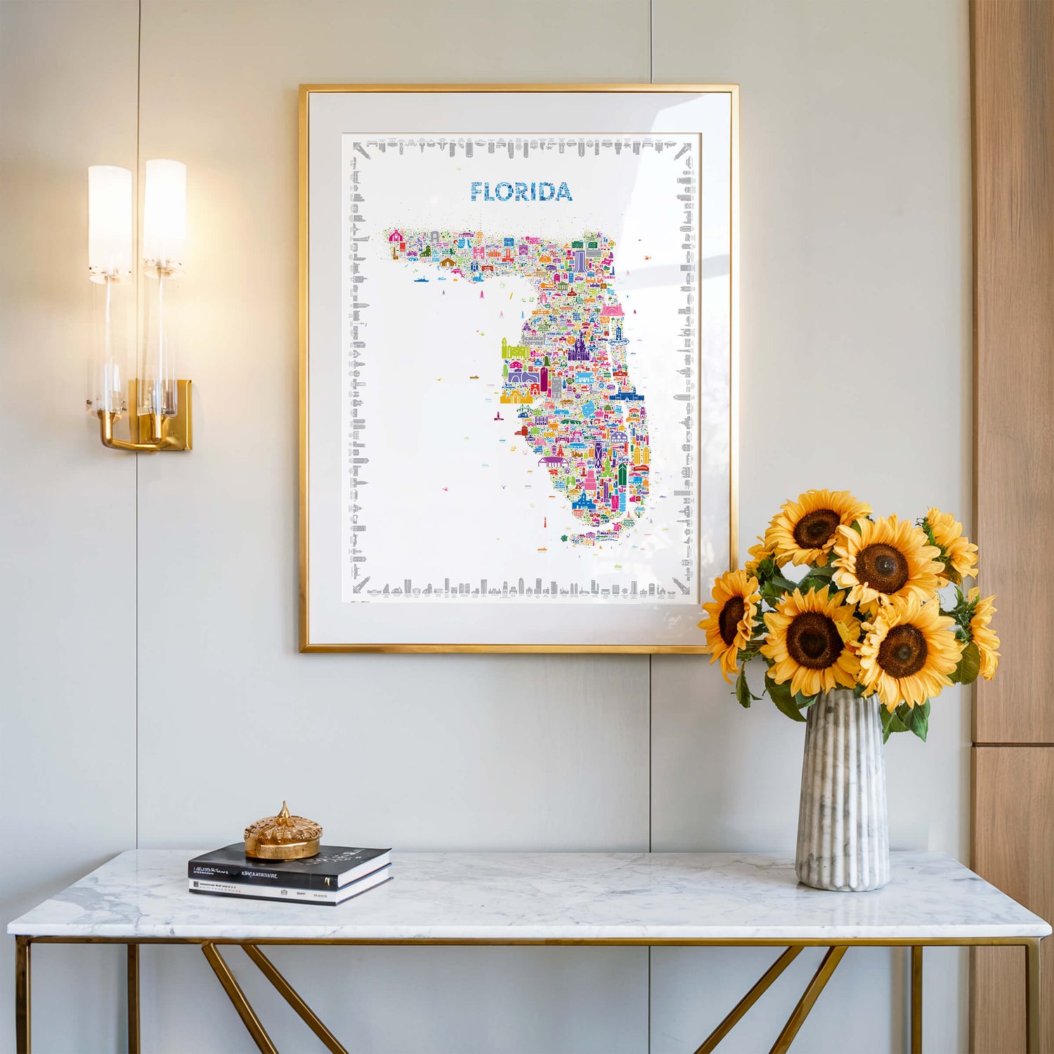 Florida map poster in gold frame above marble console with sunflowers, bright colorful wall art décor for modern interior