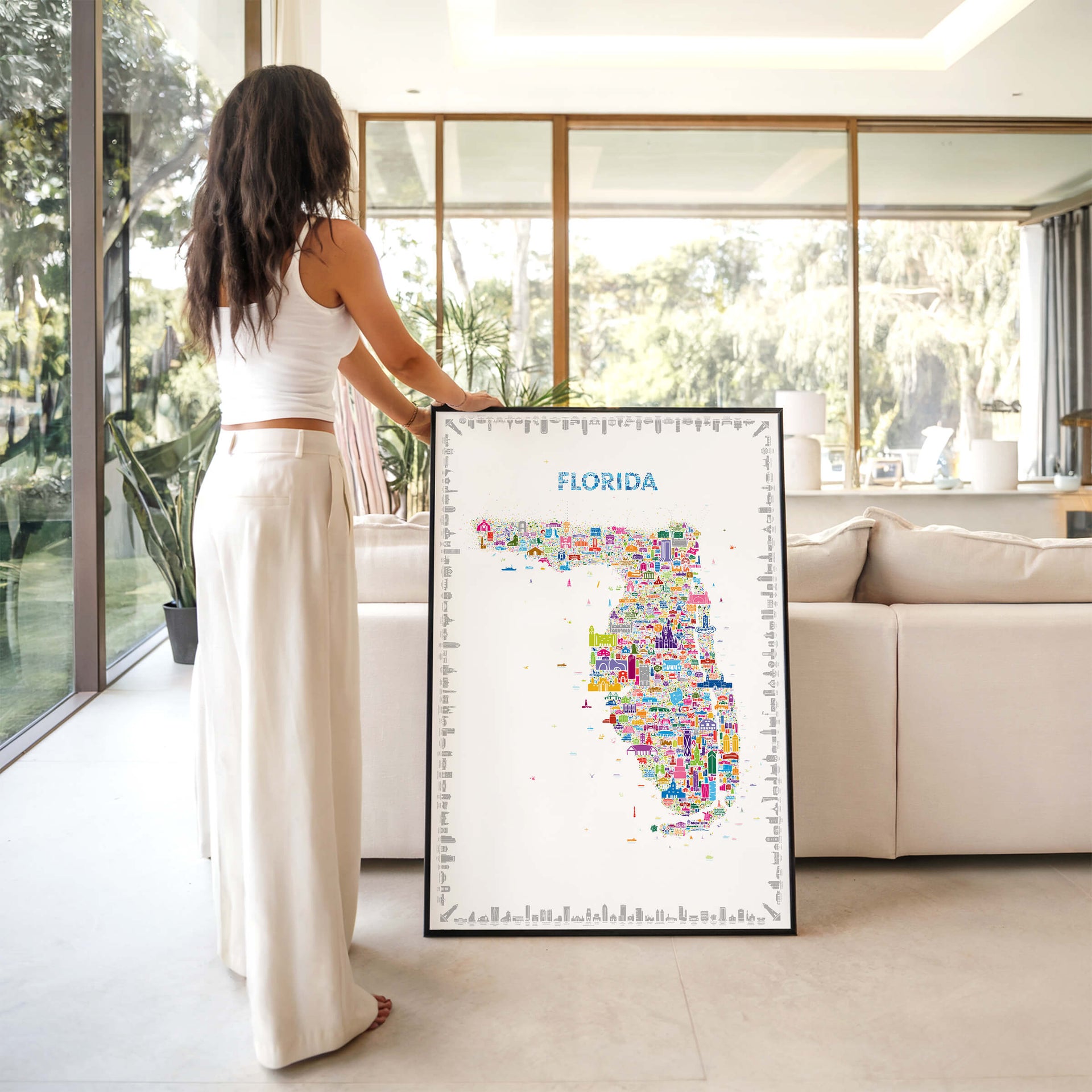 Large Iconic Florida map poster in black frame styled in modern home with natural light and person interacting, contemporary travel wall art