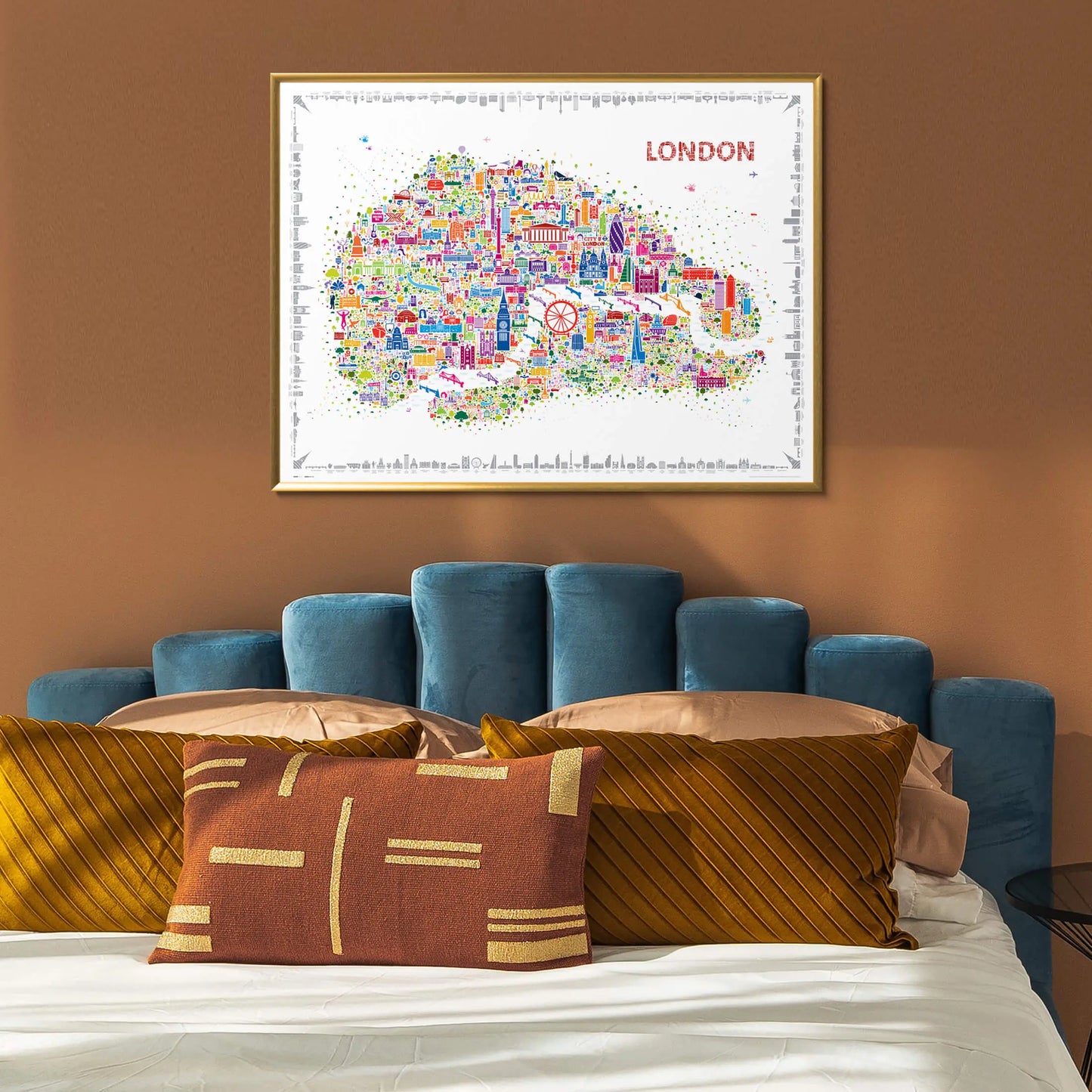 Framed map of London above a bed with decorative pillows.