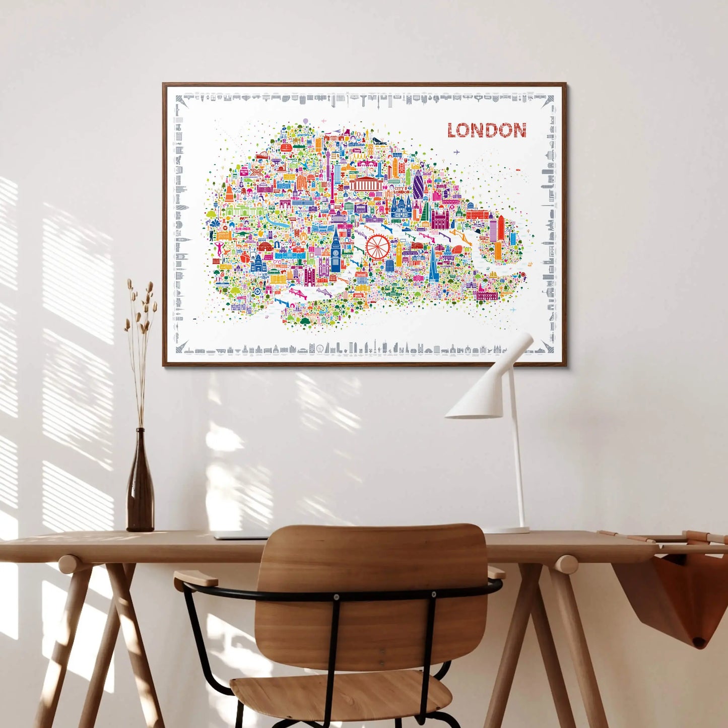 Colorful London map poster on a wall above a wooden desk with a chair.