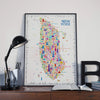Colorful New York map poster on a desk with a lamp and books.