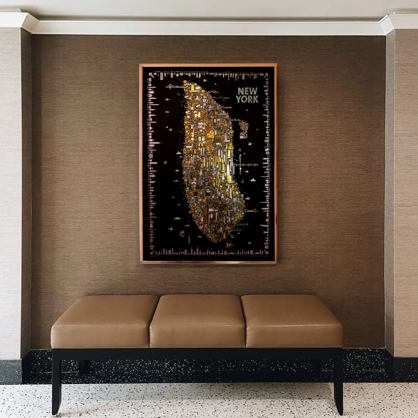 Framed map of New York City on a wall above a bench.