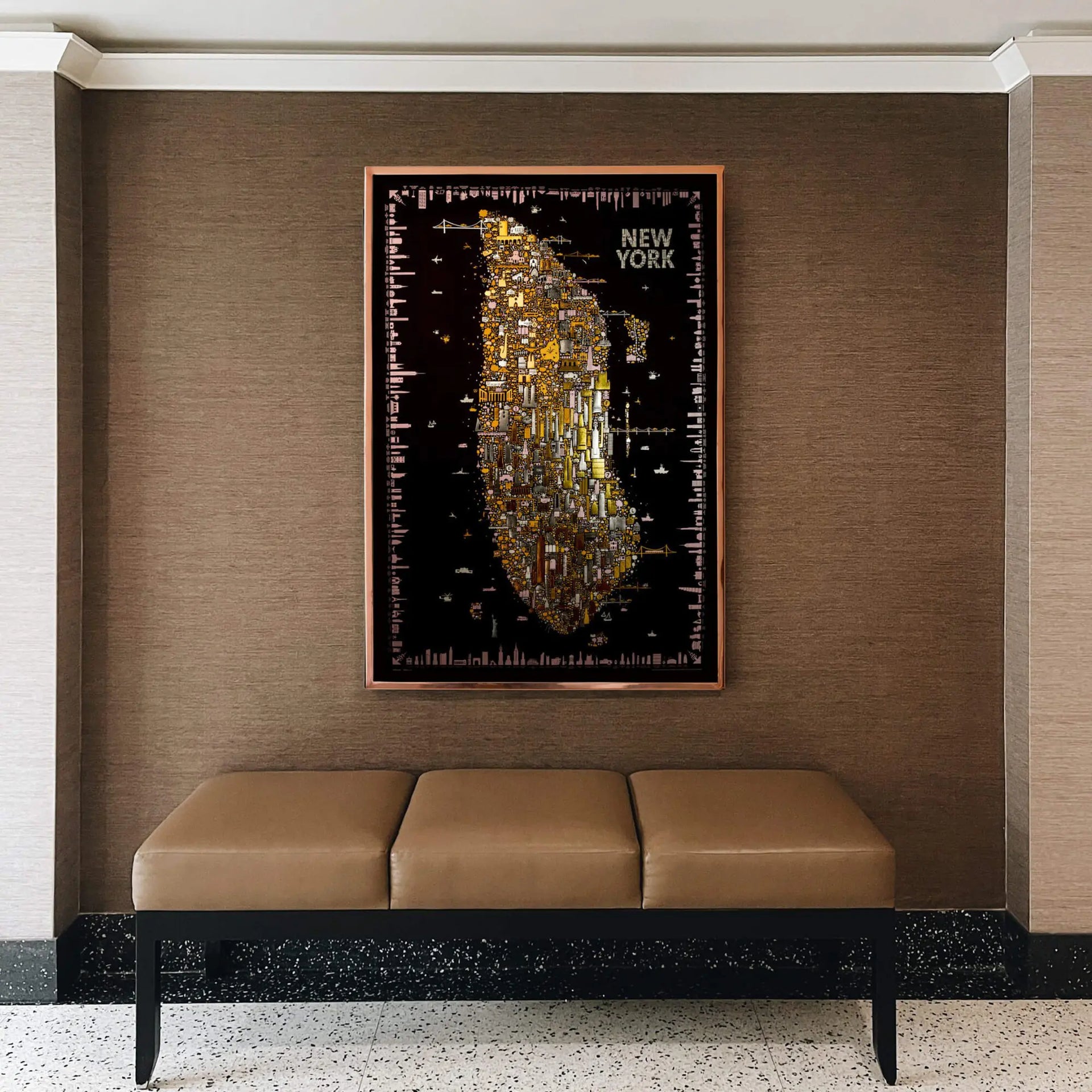 Framed map of New York City on a wall above a bench.