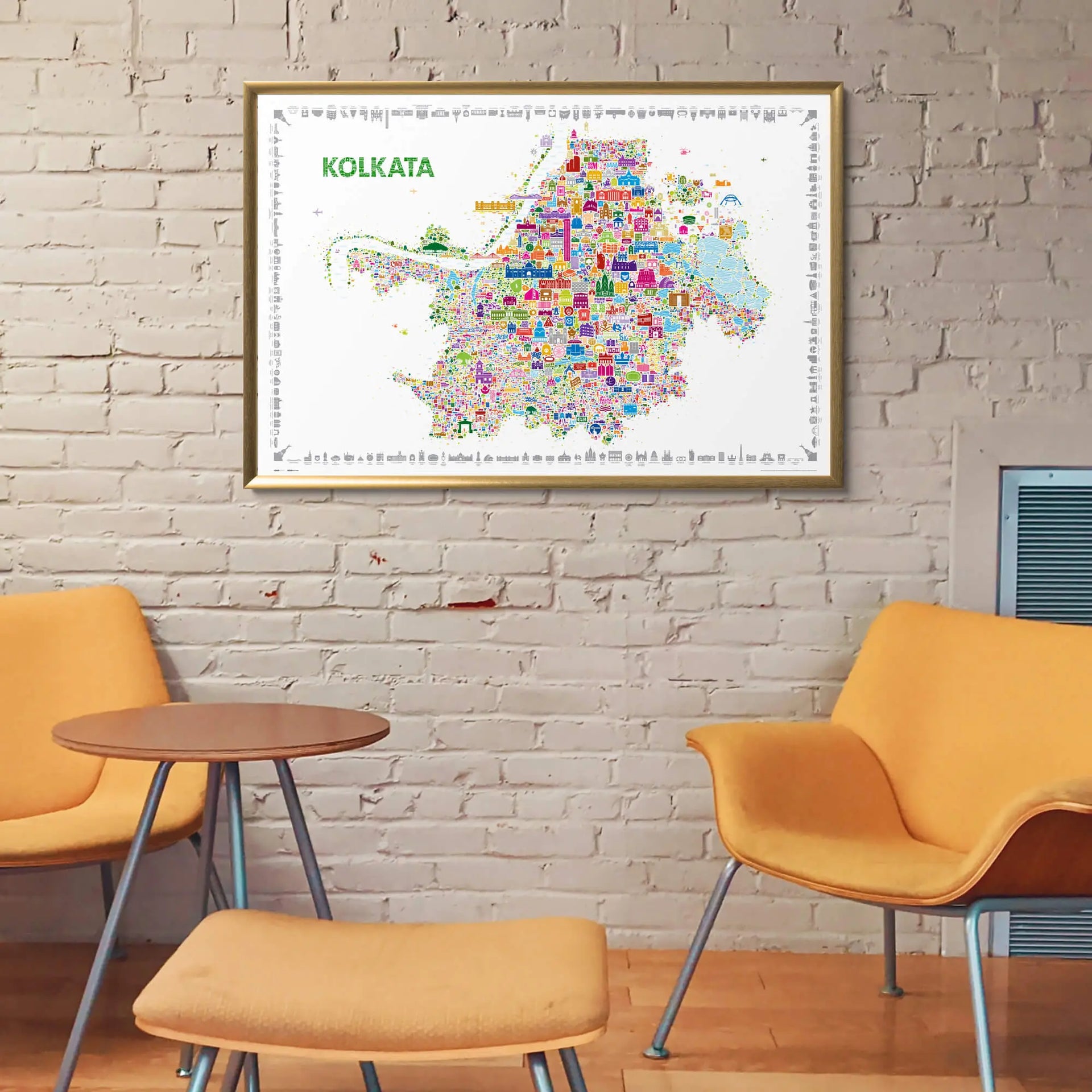 Framed map of Kolkata on a brick wall with orange chairs and a small table below.