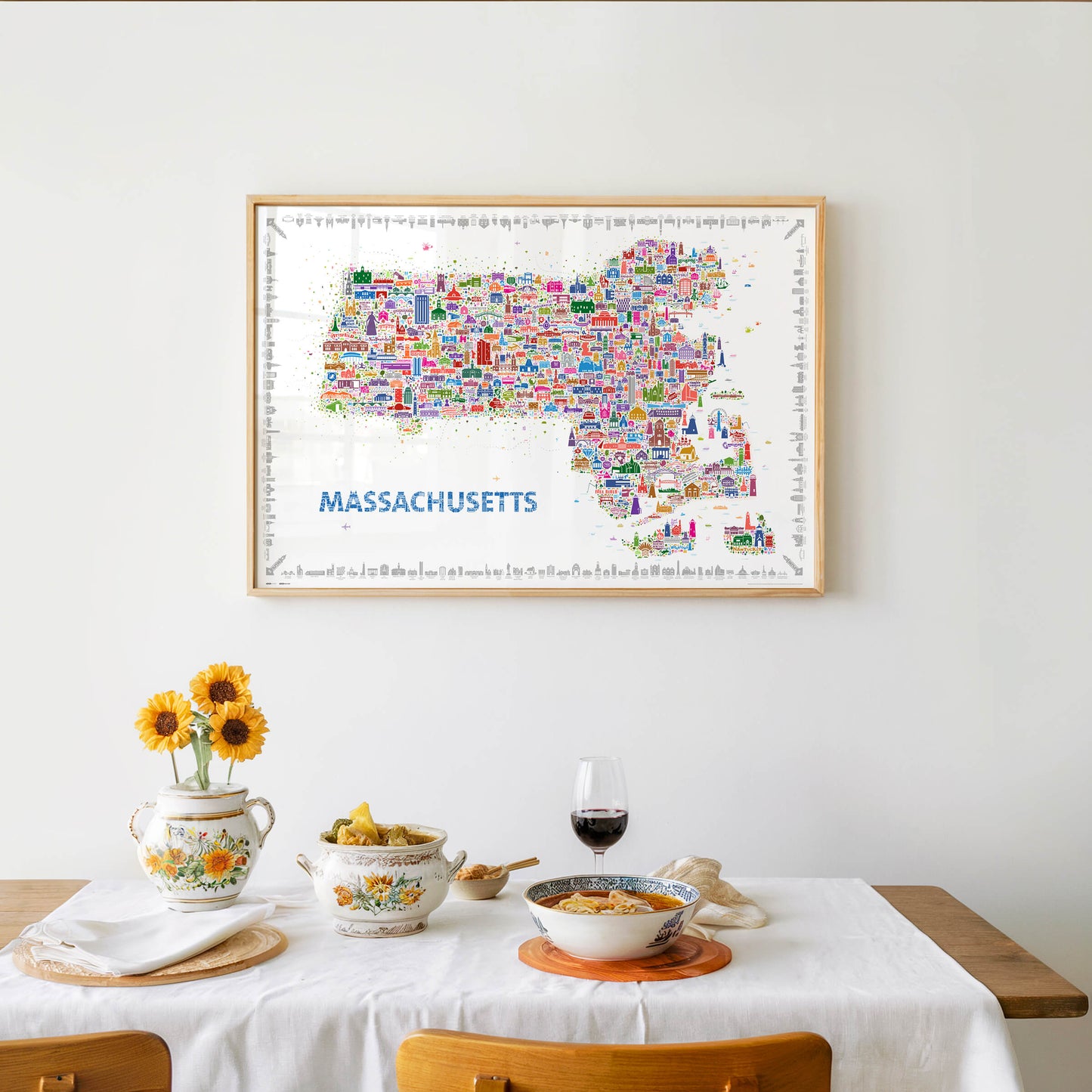 Colorful Massachusetts map poster displayed as dining room wall décor, featuring hundreds of illustrated icons of Boston and New England landmarks. A contemporary travel map artwork and modern decorative print.