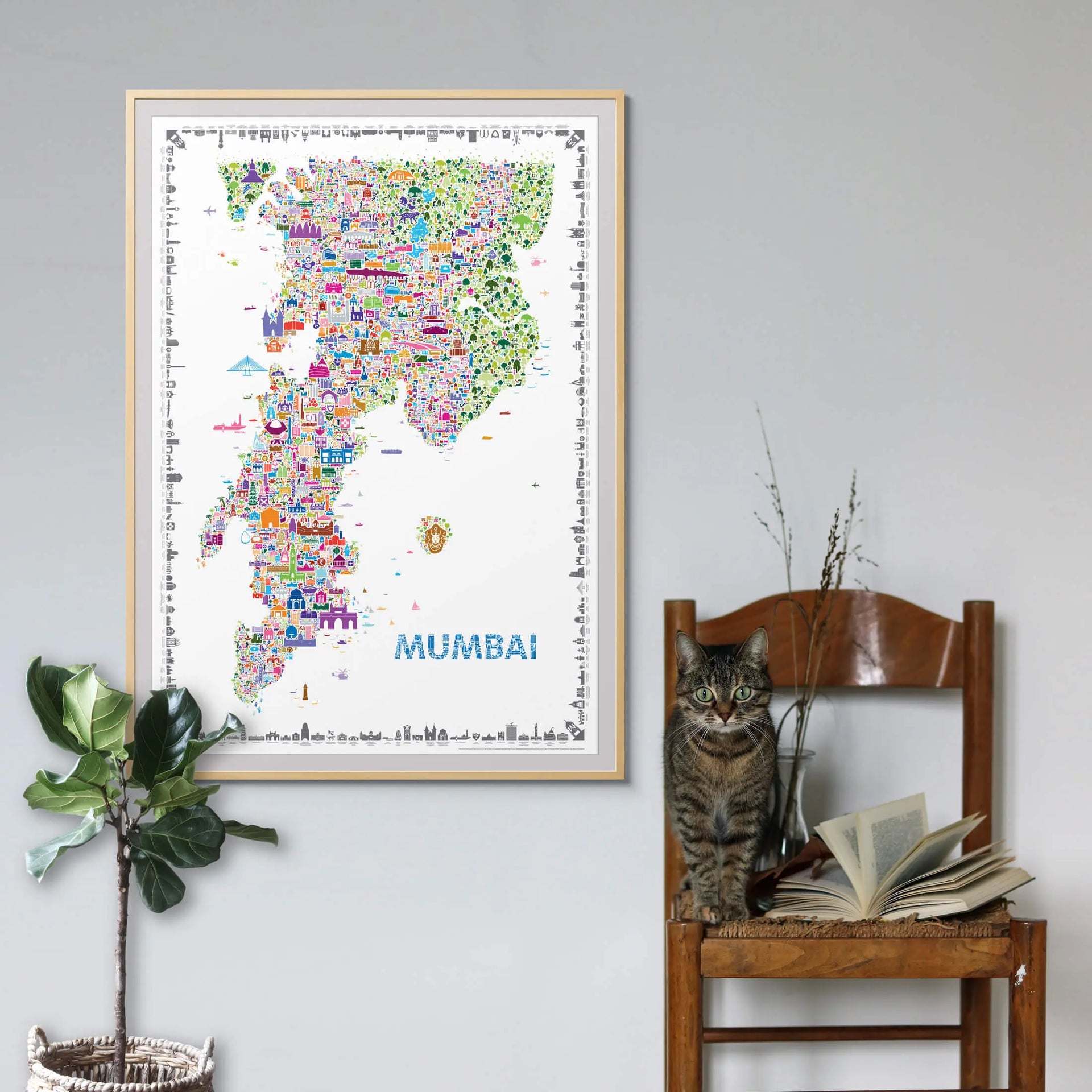 Colorful Mumbai city map art print framed in natural oak wood, displayed above a modern grey sofa — minimalist wall art decor by Alfalfa New York.