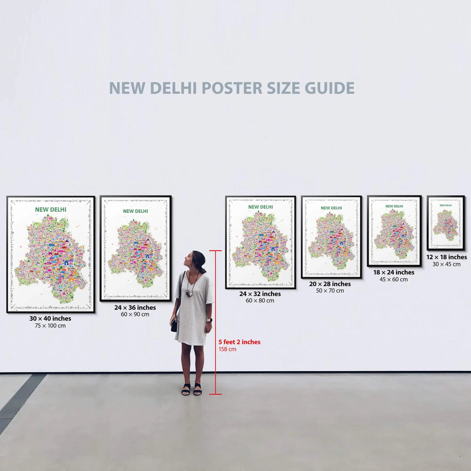 Woman standing in front of a wall displaying various sizes of New Delhi posters with dimensions listed below each.