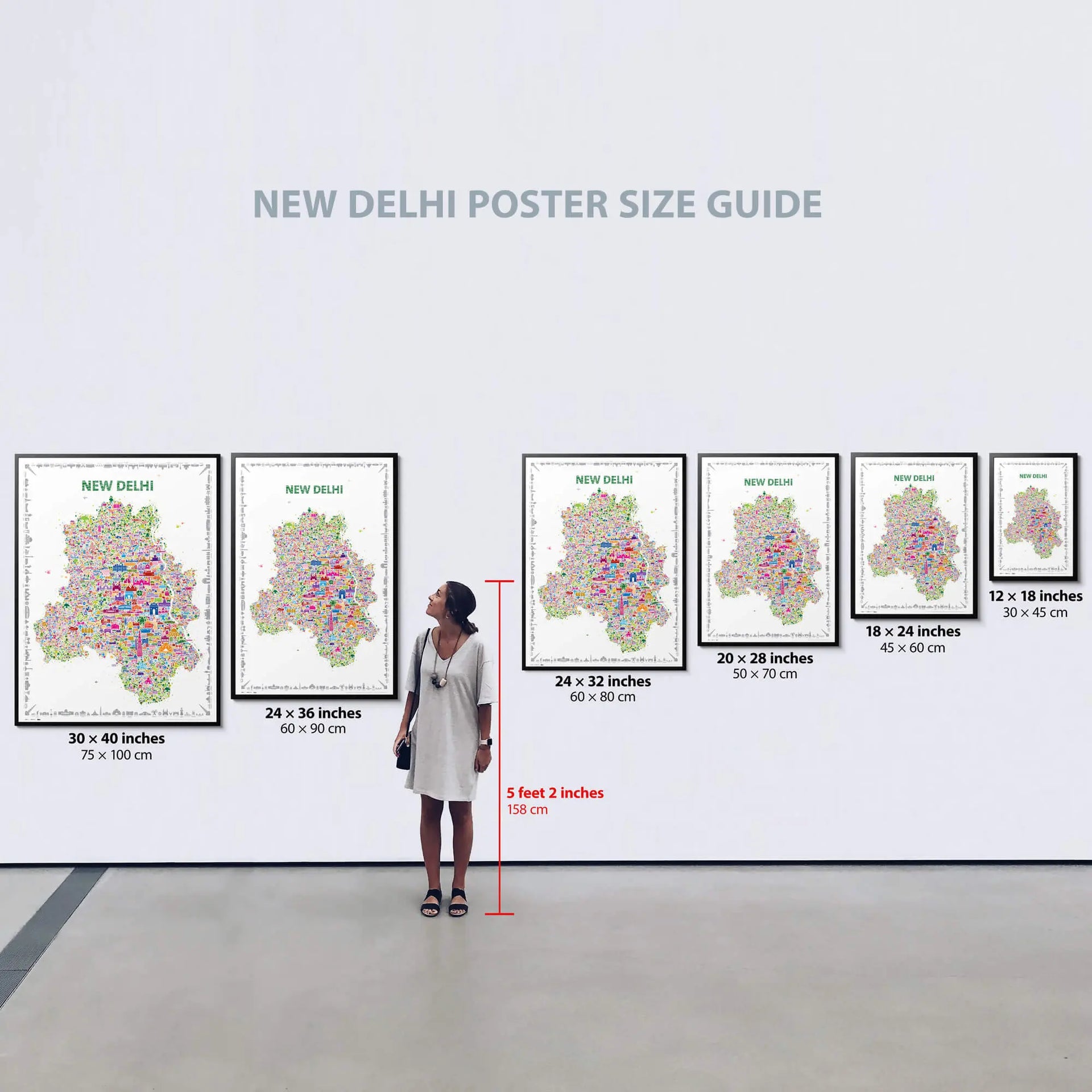 Woman standing in front of a wall displaying various sizes of New Delhi posters with dimensions listed below each.