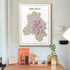 Framed map of New Delhi on a wall above a desk with decor items.