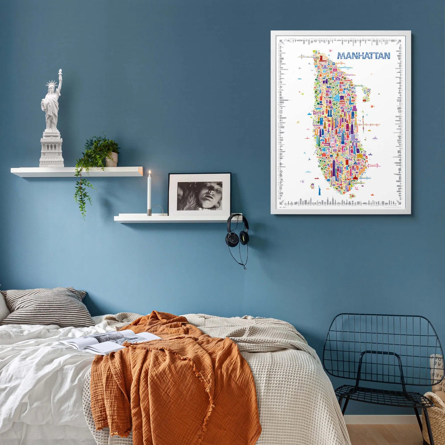 Colorful Manhattan map on a blue wall above a bed with a shelf and chair.