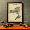 Iconic New York State Antique Map Poster in a dark frame displayed above a wooden desk with green banker lamps, a vintage NY State artwork for home office, study, or library décor.