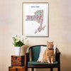 Cat sitting on a chair with a colorful New York map poster on the wall.