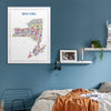 Framed New York state map art print hanging above a cozy modern bedroom with blue walls, minimalist decor, and warm bedding for a stylish urban aesthetic.