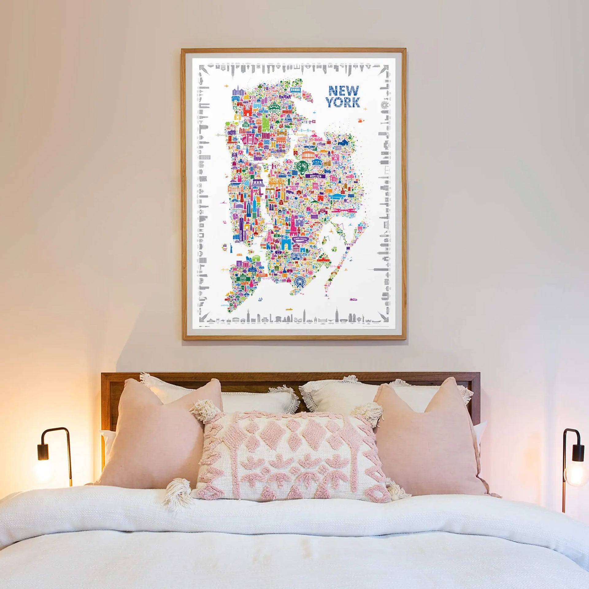 Framed map of New York on a wall above a bed with decorative pillows.
