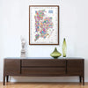 Framed Alfalfa New York illustrated map poster of New York City hanging above a modern wooden console with decorative vases and a Statue of Liberty sculpture.